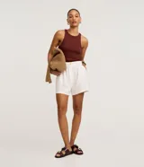 Blusa sin mangas de corte regular, confeccionada en tejido rib de algodón con cuello redondo. Presenta un diseño minimalista y anatómico, ideal para un look clásico.