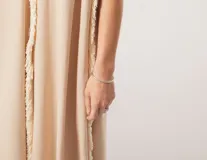 Vestido largo blanco de lino con escote en V y flecos de algodón en los bordes.