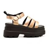 Sandalias con plataforma color dorado, con tiras horizontales y hebilla lateral.
