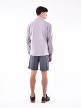 Campera deportiva azul claro, estilo cortavientos, con cuello mao y cierre frontal. Presenta puños y cintura elásticos.