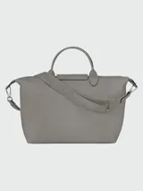 Bolso de mano Longchamp modelo Le Pliage Xtra L, color negro, confeccionado en cuero vacuno. Presenta un diseño estructurado con solapa frontal con botón a presión, doble asa superior y correa de hombro ajustable y extraíble con logo grabado.