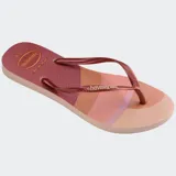 Ojotas Havaianas Slim Palette Glow con base estampada en tonos rosa, naranja y marrón, tiras finas color cobre y logo de la marca en las tiras.