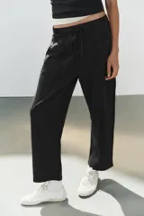 Pantalón de algodón negro con tiro medio, cintura elástica, pierna recta y grandes bolsillos laterales aplicados.