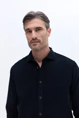 Camisa de pana de algodón con cuello clásico, cierre frontal de botones y mangas largas. Presenta un diseño de corte regular con textura suave y acabado mate.