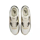 Championes Nike Air Max 90 con diseño en capas de cuero y material sintético. Presenta una combinación de colores blanco, beige y negro, con un panel lateral texturizado tipo reptil. Incluye la clásica unidad Air visible en el talón para mayor amortiguación.