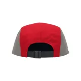 Gorro tipo cap de cinco paneles Supreme, confeccionado en tejido técnico GORE-TEX. Presenta una combinación de colores rojo y gris, con el logo de la marca bordado en un parche frontal y el logo de GORE-TEX estampado en el lateral.