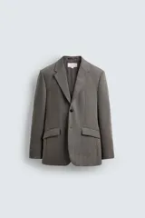 Blazer de corte regular fit confeccionado en tejido de lana de origen italiano. Presenta cuello con solapas de muesca, cierre frontal de un botón, bolsillos laterales con solapa y bolsillo de vivo en el pecho. Incluye abertura central en la espalda y forro interior con bolsillo.