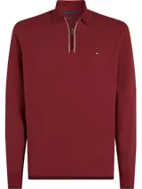 Chomba de manga larga Tommy Hilfiger confeccionada en piqué de algodón elástico, color bordó. Presenta cuello tipo polo con cierre frontal de cremallera, puños acanalados y logo de la marca bordado en el pecho.