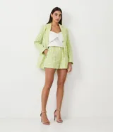 Short corto de lino con estampado de cuadros vichy en verde y blanco, con botón en forma de corazón.