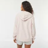 Buzo de muletón color rosado con capucha ajustable mediante cordón, cierre frontal de cremallera y bolsillos tipo canguro.