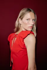 Top rojo de popelín con escote en V pronunciado, mangas sisa y pespuntes en contraste. Cuenta con tirantes finos cruzados y lazada en la espalda.