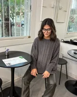 Sweater de punto con diseño de trenzas verticales y efecto de lavado, cuello redondo y mangas largas con puños acanalados.