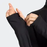 Campera deportiva New Balance con cierre frontal completo, cuello alto y mangas largas con agujeros para los pulgares. Presenta un tejido de punto teñido en espacio (space dye) en tonos oscuros y el logo NB reflectante en el pecho.