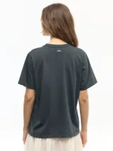 Remera negra de manga corta con cuello redondo, confeccionada en jersey de algodón, de calce regular y largo a la cadera, con estampa frontal inspirada en la película "Une femme sous influence".