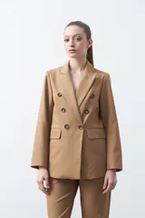 Blazer sastrero negro de doble botonadura con botones marrones, cuello solapa y mangas tres cuartos. Tiene dos bolsillos delanteros con solapa.