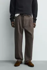 Pantalón straight fit color negro confeccionado en tejido con lana, con detalle de pliegues en el delantero, bolsillos frontales y traseros, y cierre frontal con cremallera y botón.