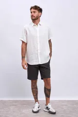 Camisa de lino blanca de manga corta, con cuello clásico y botones frontales.