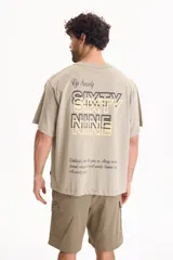 Remera oversize verde claro de manga corta, con diseño gráfico y texto estampado en la espalda.