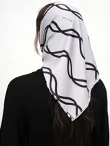 Pañuelo de seda blanco con estampado de líneas curvas en color verde lima, y texto sutil en la tela.