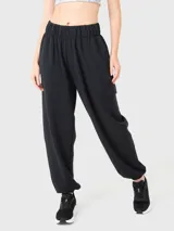 Pantalón de buzo negro de tela suave, con bolsillos laterales, bolsillo trasero y elástico en los tobillos.