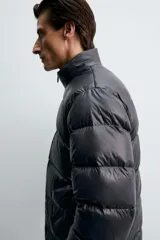 Cazadora acolchada de corte regular, confeccionada en tejido técnico repelente al agua. Presenta cuello subido, cierre frontal de cremallera, mangas largas con puños elásticos y bolsillos laterales con cremallera oculta.