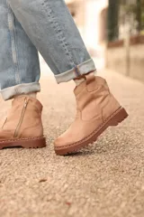 Bota corta color taupé con caña baja, corte lateral elástico y suela track.