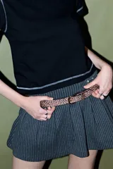 Cinturón de cuero sintético con estampado animal print de leopardo en tonos marrones y negros, con hebilla metálica dorada.