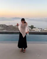 Poncho tejido de punto abierto, color blanco, con textura arrugada y bordes ondulados.