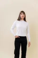 Buzo de tejido fino color amarillo claro, con cuello semi alto, manga larga y calce regular.