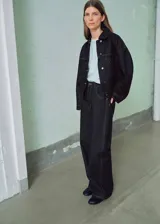 Jeans Susan de tiro alto y diseño balloon, confeccionados en tejido de algodón estilo vaquero en color negro con costuras pespunteadas en contraste. Cuentan con cierre de botón y cremallera, presillas para cinturón y diseño de cinco bolsillos.