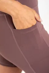 Short tipo biker de tiro alto, confeccionado en tejido técnico elástico de secado rápido, con costuras reforzadas y bolsillos laterales integrados.