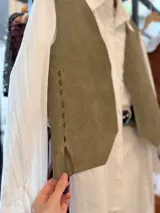 Chaleco artesanal confeccionado en cuero, con diseño de cordones decorativos en el frente y terminaciones rústicas.