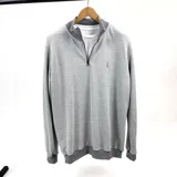 Buzo de algodón de punto color gris con medio cierre frontal y cuello alto.