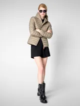 Campera puffer beige con capucha, cierre frontal con cremallera naranja, bolsillos laterales ocultos y logo de goma en la manga. Confeccionada en nylon liviano y con puños y dobladillo elásticos de Lycra.