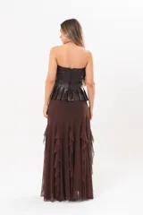 Pollera larga color chocolate confeccionada en microtul, totalmente forrada, con diseño fluido y volados en cascada que aportan movimiento.
