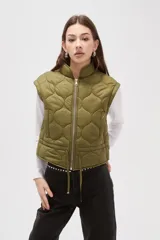 Chaleco acolchado color verde oliva, con diseño de costuras circulares, cierre frontal metálico y cordón ajustable en la cintura.