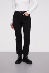 Pantalon jean de corte flare, tiro medio, con diseño de cinco bolsillos y ruedo desflecado.