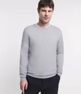 Suéter de punto color borgoña, con cuello redondo, sisas ligeramente desplazadas y bajo y puños acanalados.