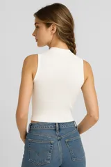 Top blanco de viscosa con cuello alto y corte entallado.