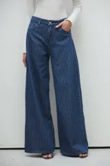Pantalón palazzo de jean azul con rayas verticales blancas.