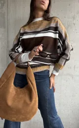 Sweater de punto con diseño de rayas horizontales en tonos chocolate, mostaza, blanco y gris. Presenta cuello redondo, mangas largas y corte holgado.