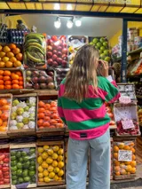 Sweater a rayas horizontales rosas y verdes, con cuello polo blanco y puños blancos.