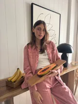 Chaqueta de jean azul, de corte entallado, con cuello camisero, cierre frontal con botones y bolsillos delanteros con solapa.