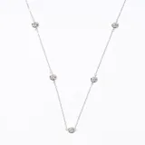 Collar plateado con cadena fina y cinco dijes redondos con piedras brillantes engarzadas.