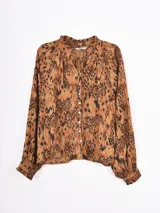 Camisa de manga larga con estampado animal print en tonos marrones y negros. Presenta cuello con volados, cierre frontal con botones y puños con volados.