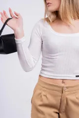 Remera corta color marrón con estampado animal print de leopardo, escote asimétrico y manga larga.