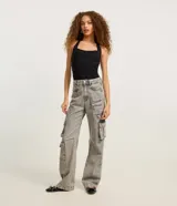Pantalón cargo de jean gris con lavado ácido, corte recto, tiro medio y múltiples bolsillos laterales.