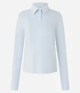 Blusa tipo polo de manga larga, confeccionada en tejido interlock de algodón y poliéster. Presenta cuello clásico con cierre frontal de botones y diseño básico liso.