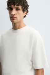 Camiseta de corte relajado confeccionada en algodón compacto, con cuello redondo y mangas cortas sin costura de sisa.