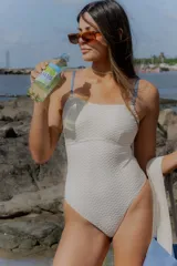 Malla enteriza color natural con textura tipo waffle, escote recto y breteles finos en color azul.